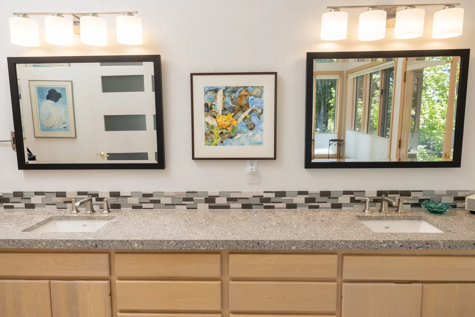 Bath designed by Kalluna Interior Design — Warm wood cabinetry, wide mirrors and a patterned backsplash across a shared double vanity.