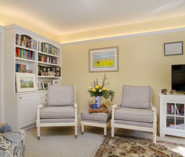 A cozy living room sitting area with houndstooth chairs, built-in bookshelves, and layered textiles that make the space feel collected and lived in.
